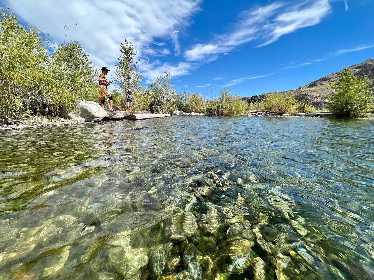 Panoramic collage of a clear river with rocky banks, bright blue skies, and green foliage under sunny conditions.