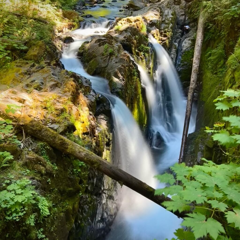 A serene waterfall cascades over mossy rocks in the lush forest of Jade Gap, Snoqualmie Falls, Washington.