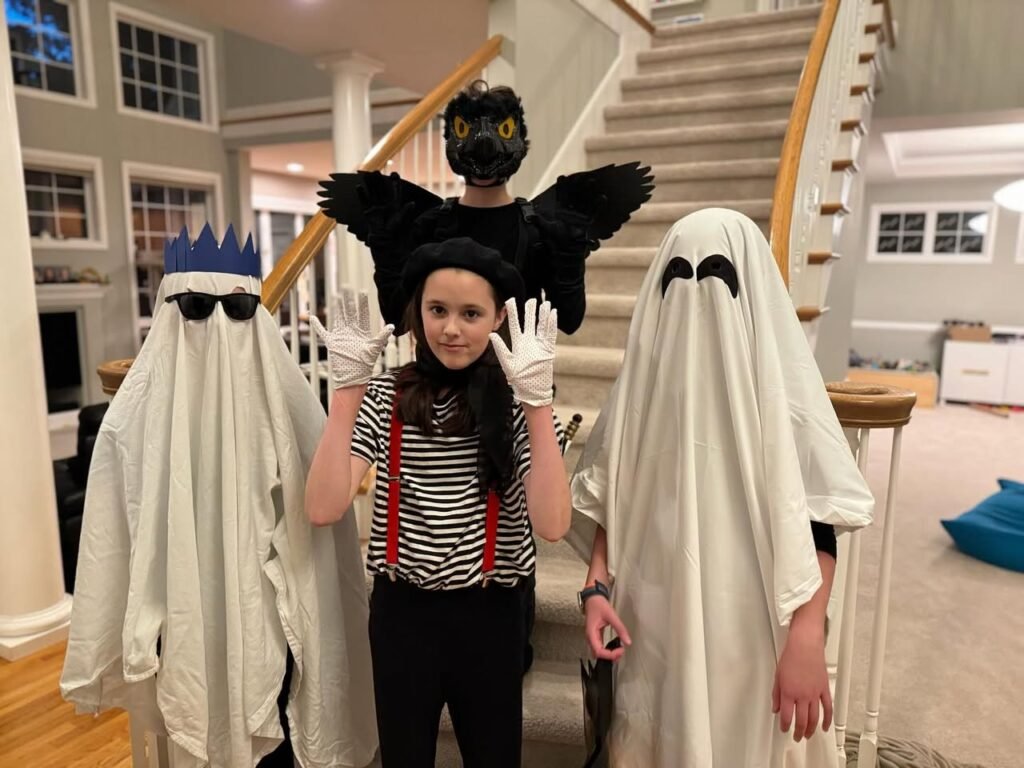 A family posing in creative Halloween costumes before a staircase.