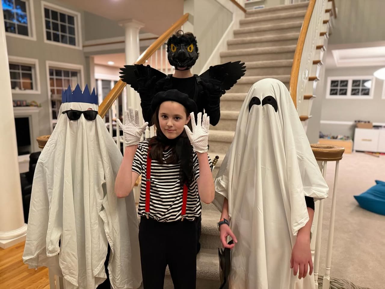 A family posing in creative Halloween costumes before a staircase.