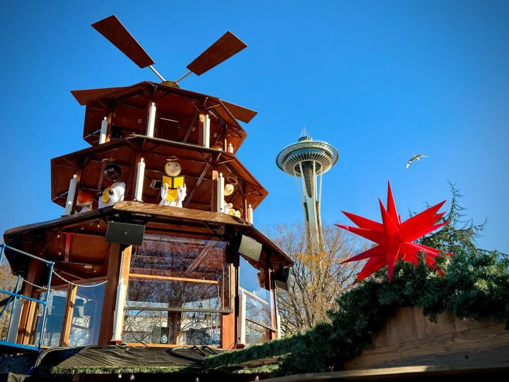 A wooden tower and a red star viewed alongside the Space Needle.