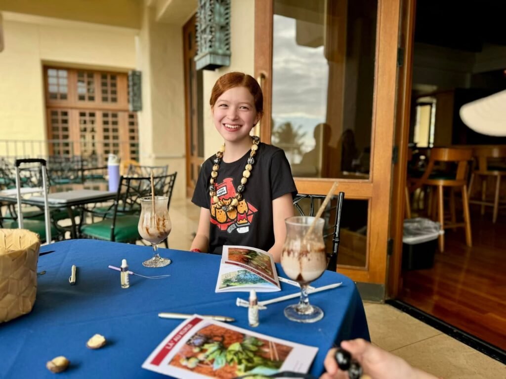 A family member enjoying dessert and reading at a table in a rustic setting.