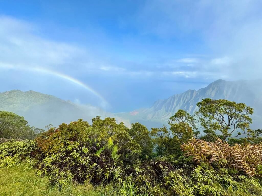 A vibrant rainbow arcs above mountain peaks during a Pacific Northwest travel adventure.