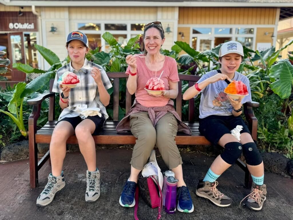 A family enjoys shaved ice at a Hilo, Hawaii cafe. The group shares colorful treats in a tropical setting.
