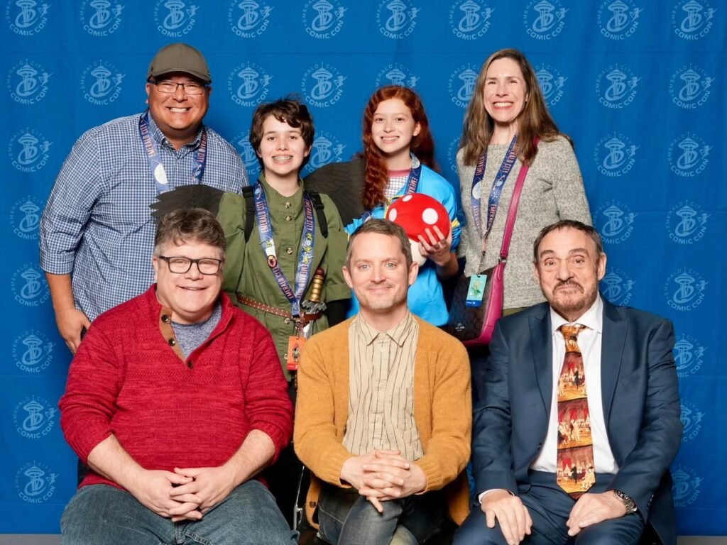 A group of people posing in front of a blue backdrop featuring the San Diego Zoo Global logo.