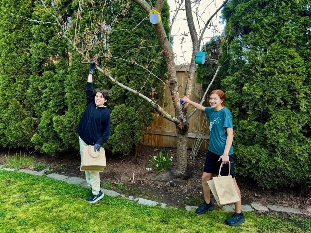 Two players enjoy a game of hangman in a lush, sunlit garden with paper bags in hand.