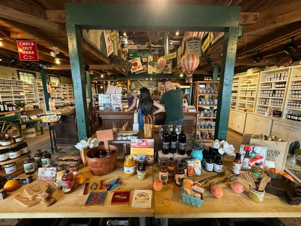 A display table full of local goods in a rustic general store with wooden ceilings and shelves.