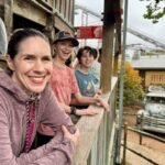 2024 Solar Eclipse A family enjoys a day at an amusement park, watching the rides and attractions from a wooden stand.