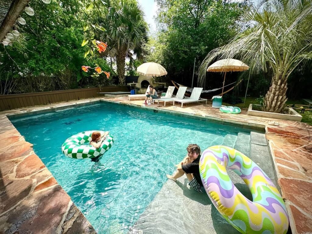 Relaxing in a tropical pool with colorful float rings and lush green palm trees.