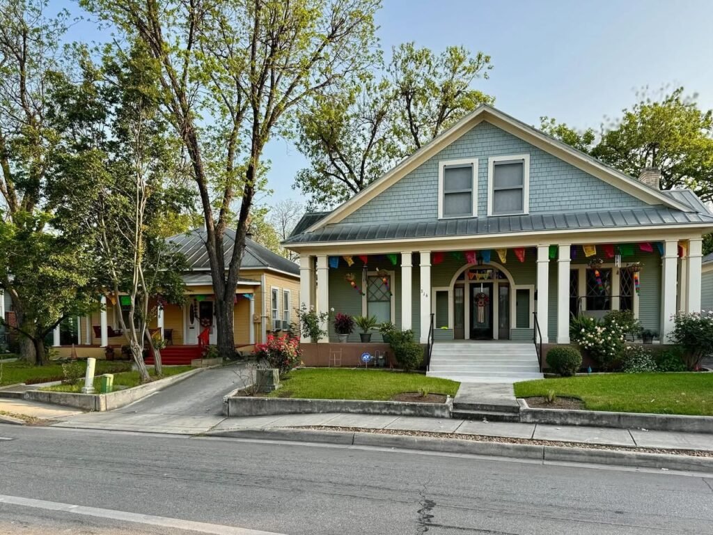 A beautifully preserved historic yellow house with a wraparound porch and vibrant green lawn. This image was captured during our family road trip through the Southern United States.