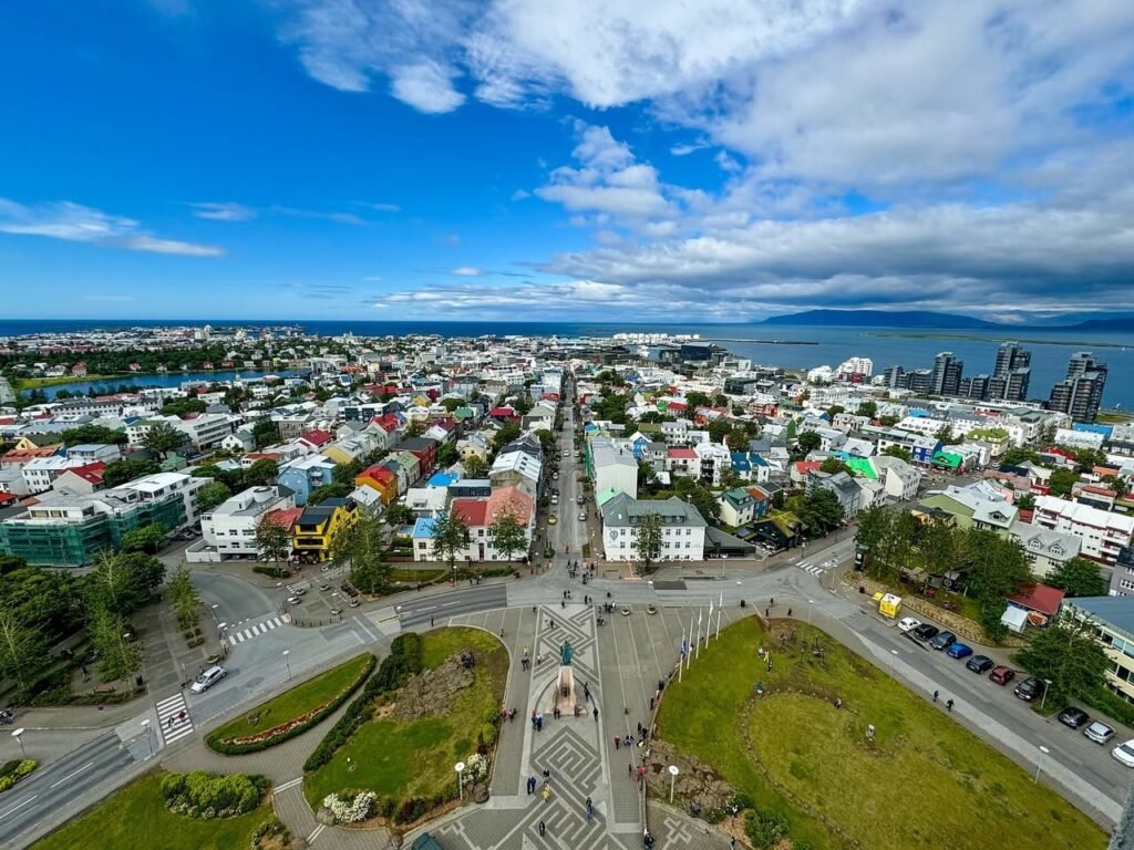 Aerial panorama of Valparaiso's grid-like center and colorful houses under a bright, partly cloudy sky.