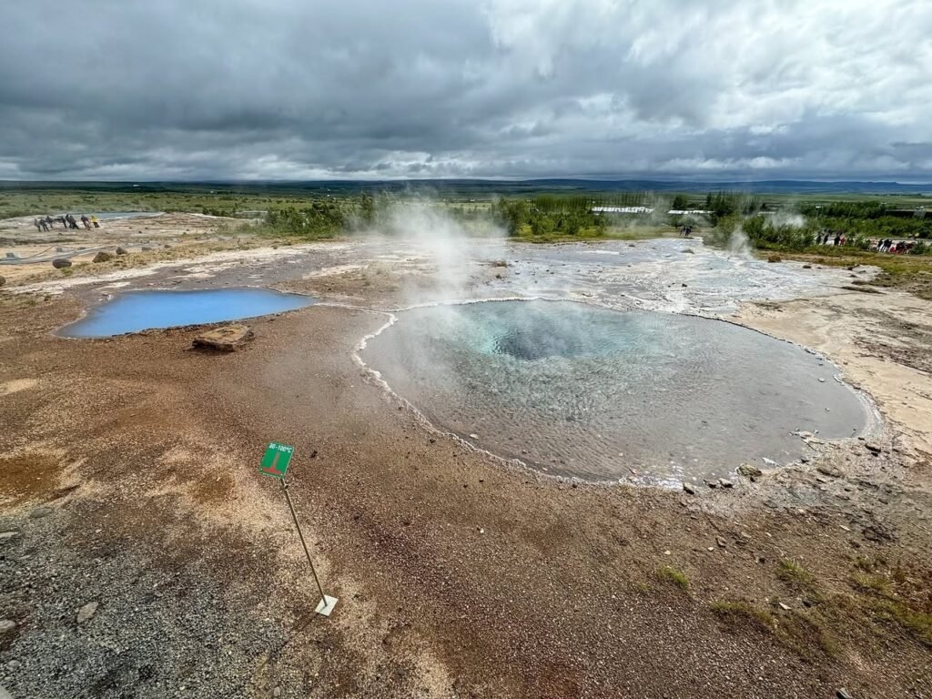 Geothermal activity in a steam field with bubbling thermal pools.