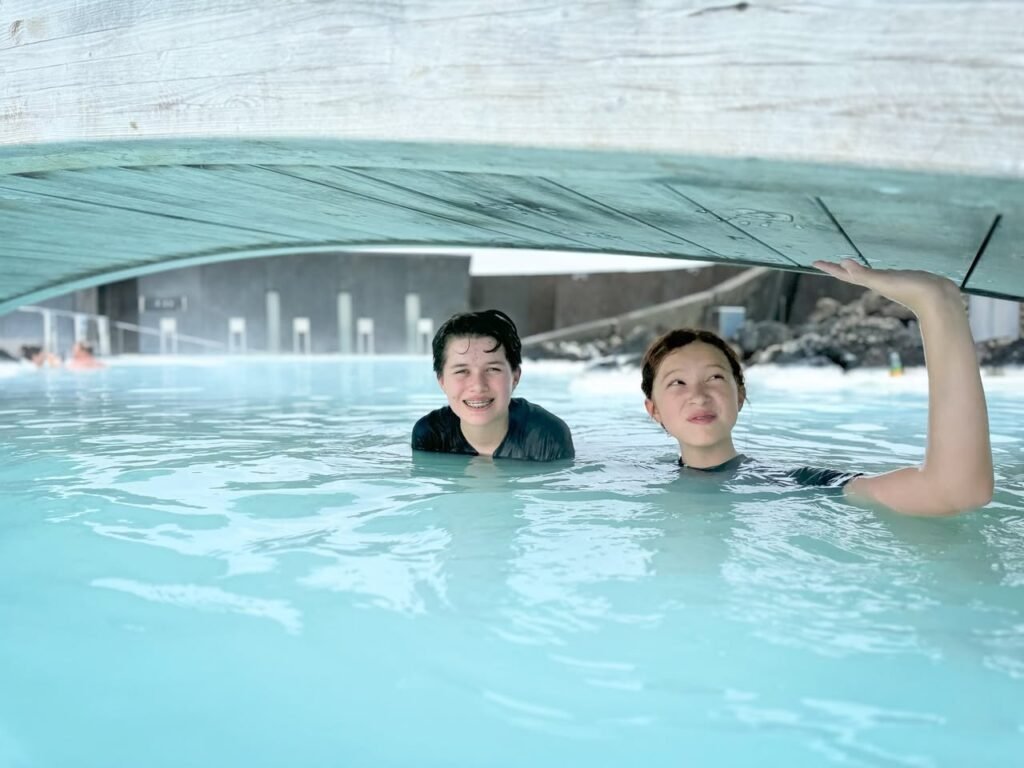 Two people enjoy the wellness pool under a unique glass structure in central Tubingen.