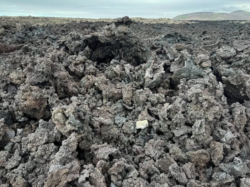 Wild volcanic crater with rough, dark ash and other mineral deposits