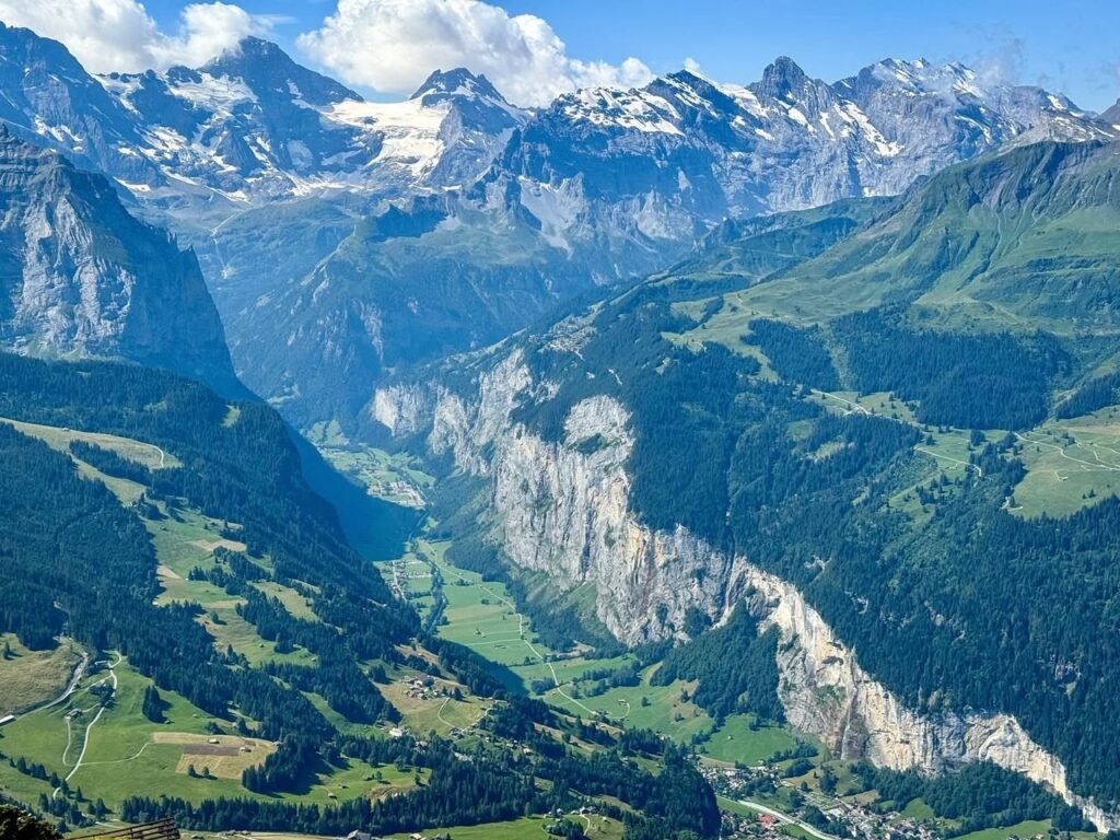 Sweeping views of snow-capped mountain peaks and lush green valleys.