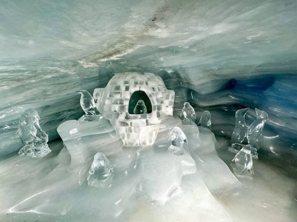 A detailed view of carved ice sculptures and natural cave formations with blue hues.