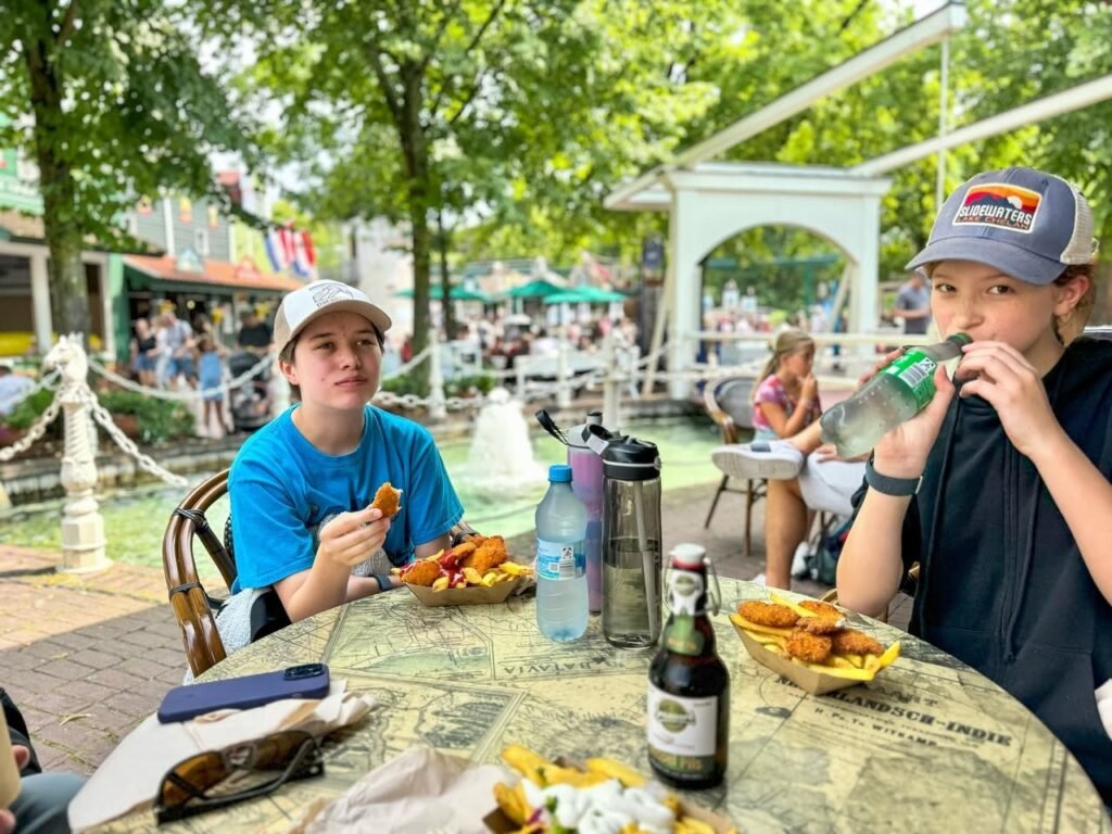 Family enjoying a relaxing meal at an outdoor cafe with table food and beverages.