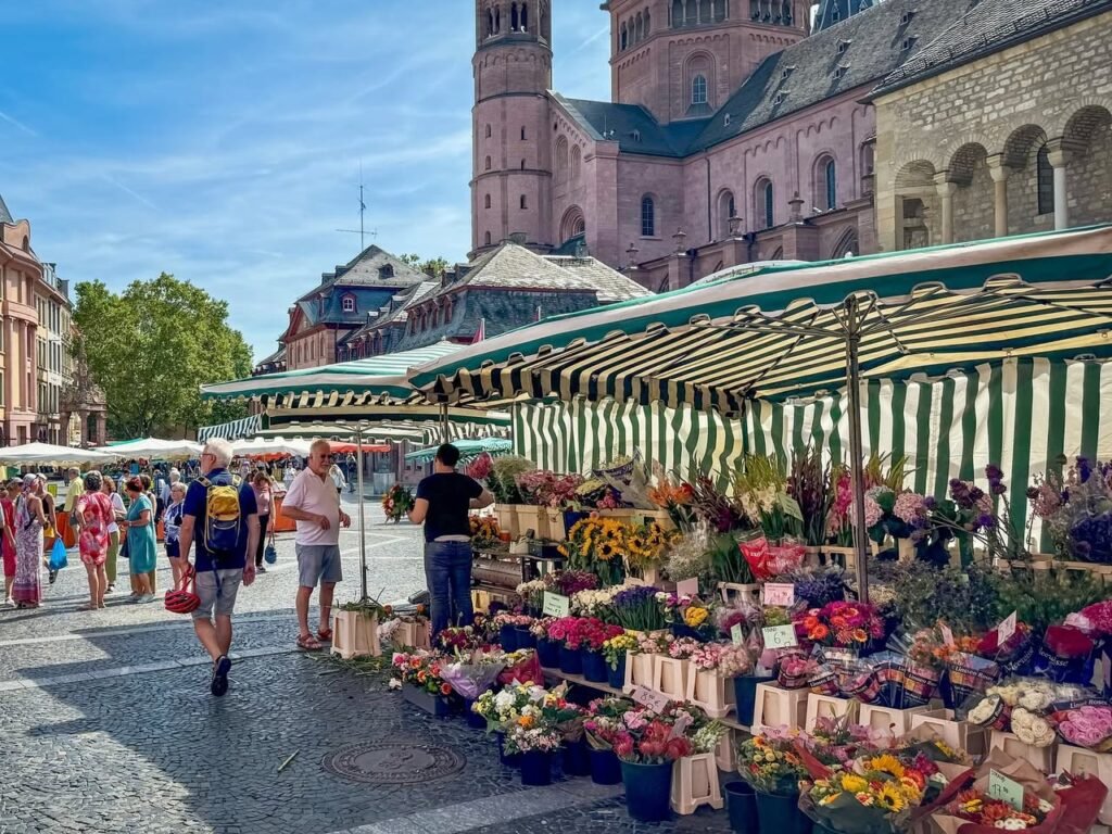 A view of Cologne Cathedral in the background with a flower market in the foreground.