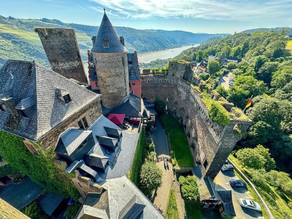 An aerial view of Eltz Castle showcasing its gothic architecture and surrounding lush green valley in Germany.
