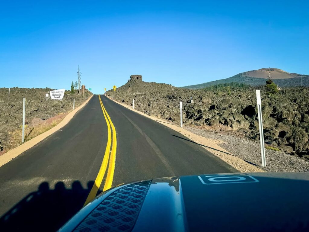 Roads winding through a volcanic landscape with clear blue skies and distant hills.