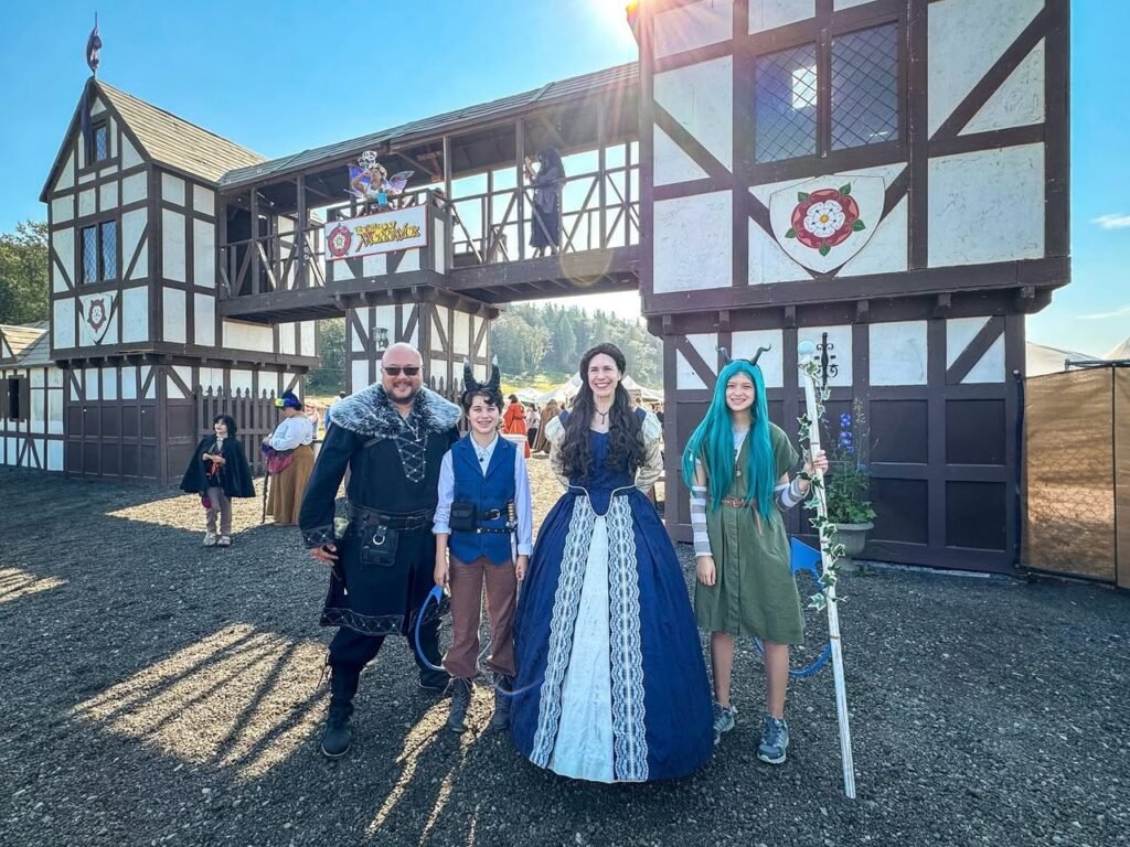 A family posing in front of a historic Tudor-style building at a medieval themed festival.