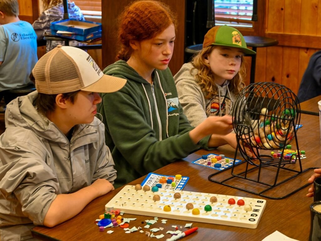 A group of kids are engaged in a board game at a table indoors.