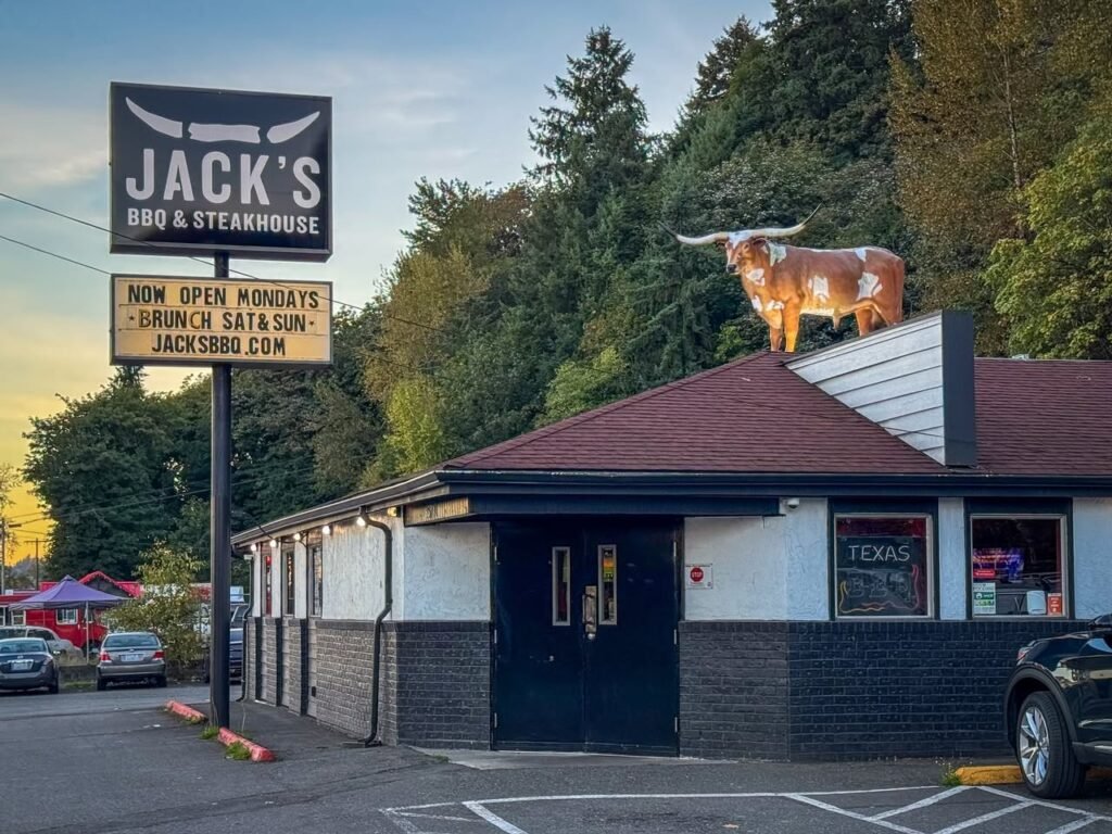 A collage of views from Jack's BBQ and Steakhouse, showing a longhorn bull on the roof, the prominent exterior sign, and restaurant details.