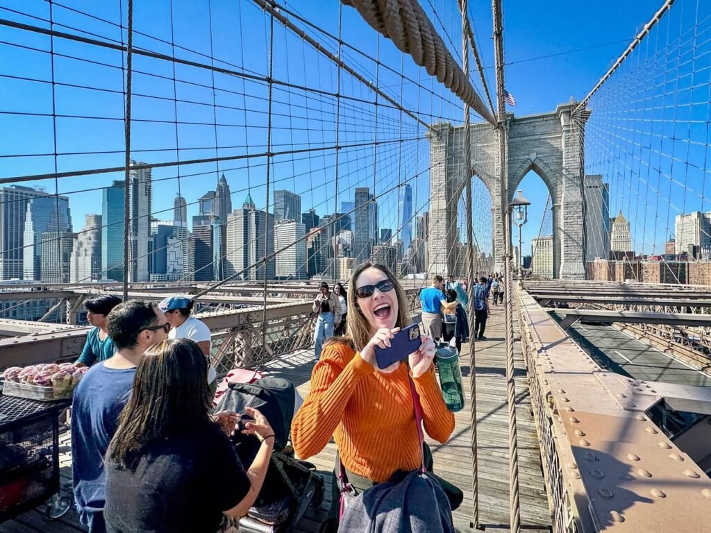 A joyful moment on the Brooklyn Bridge with stunning views of the New York City skyline.