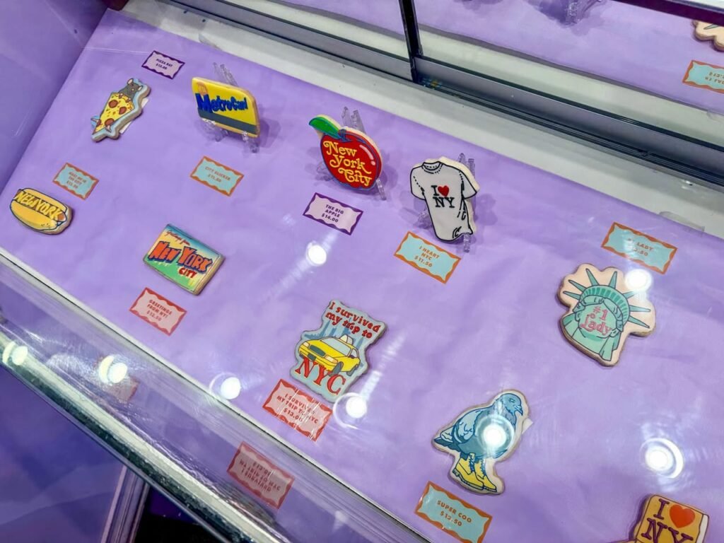 A collection of 80s-themed pins on a purple display, including icons of a record, a tee, and a statue.