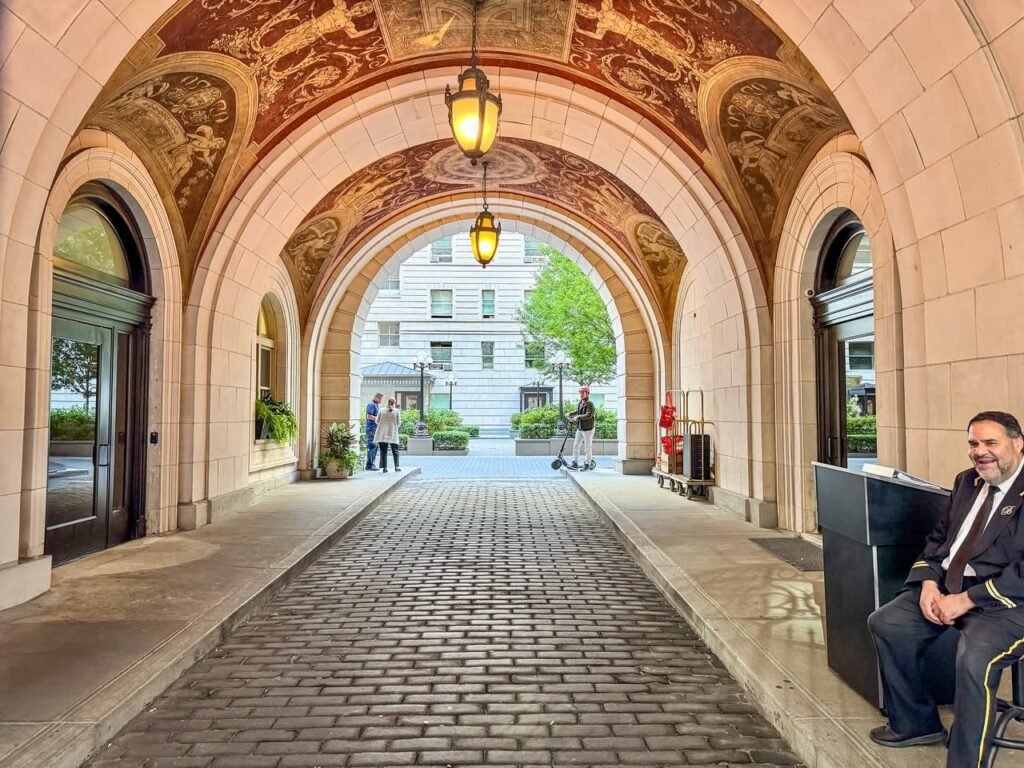 A series of photographs showing ornate, patterned ceilings over light stone arches and a cobbled walkway in an historical courtyard.