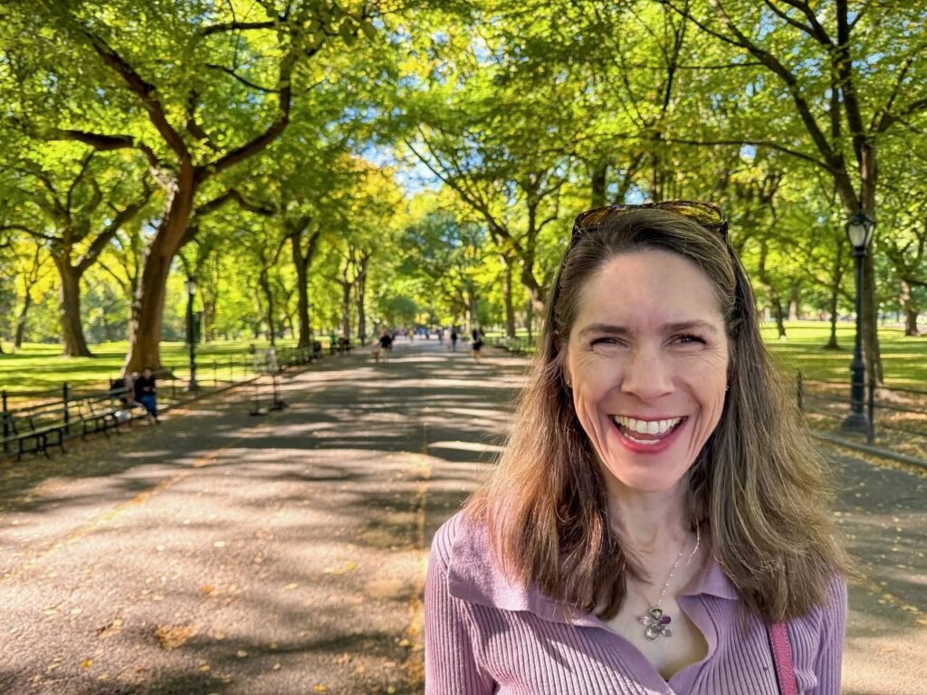 A smiling person and a close-up of a tree-lined park pathway.