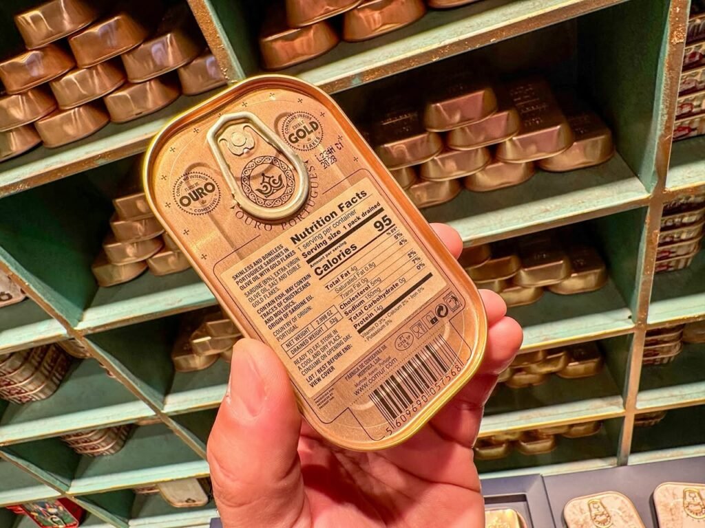 A person holds a panel of Oreo Gold cookies with shelves filled with similar packages in the background.