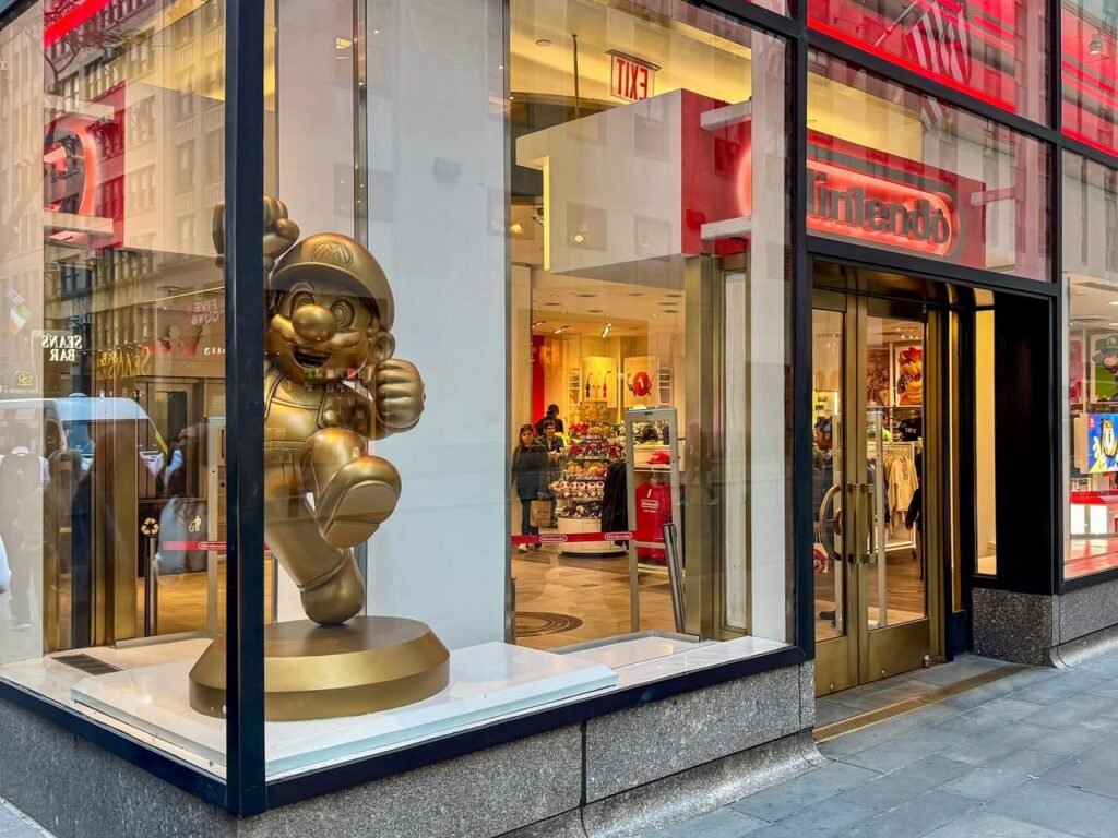 A golden character statue is displayed in the window of a Levi's store. The glass reflects the surrounding city architecture.
