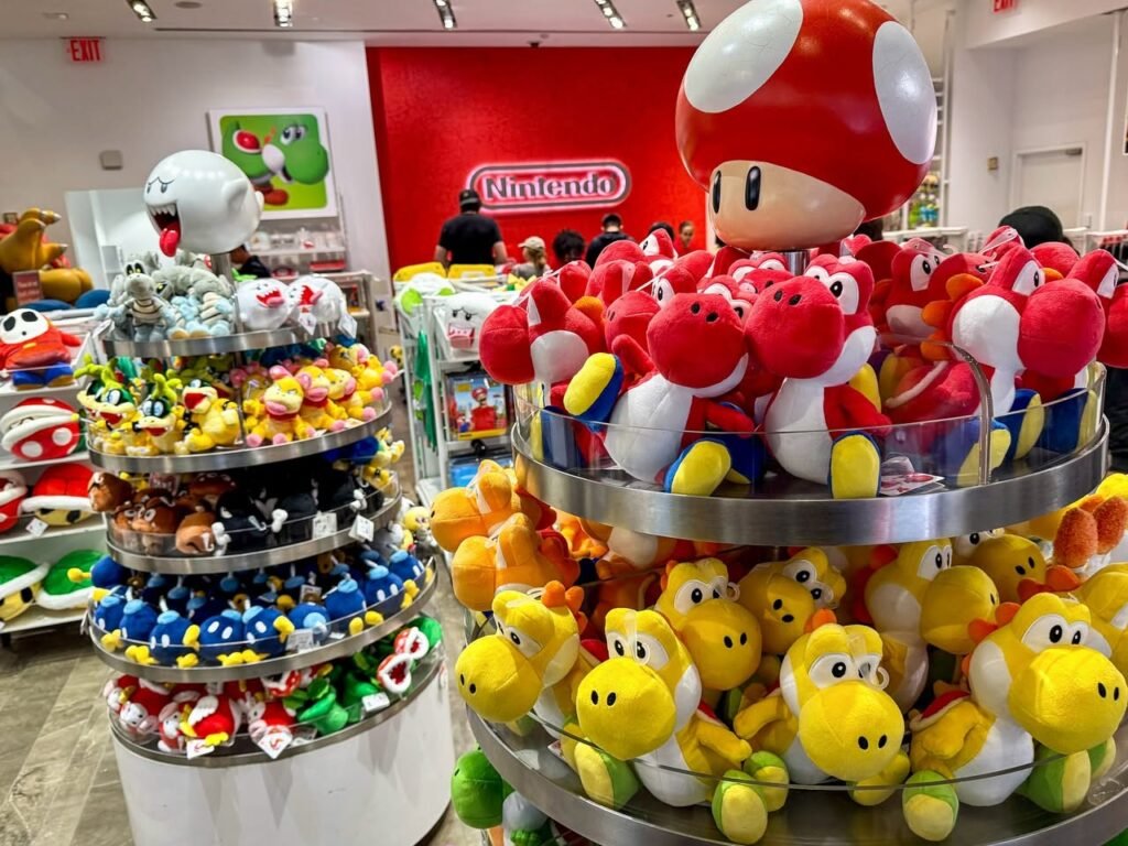 A display of red Yoshi toys in front of a Nintendo logo.