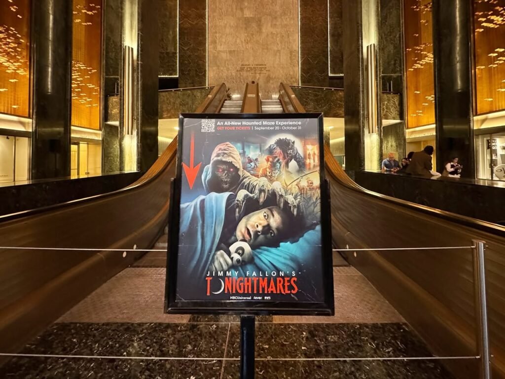 A movie poster for the film Nightmares is displayed on a platform between two escalators with warm golden lighting in the background.