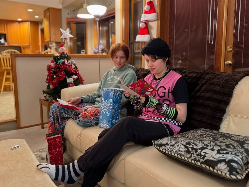 Family members on a couch exchanging gifts during a cozy holiday morning. Close-up details of the festive decor and people in the images.