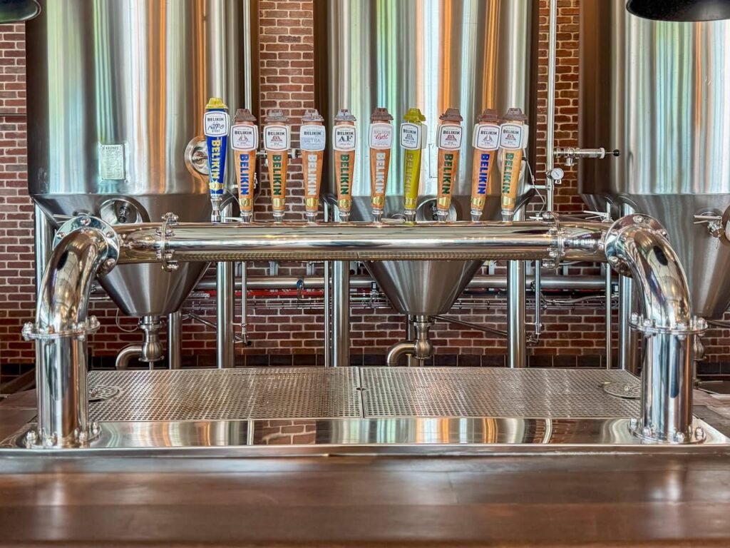 A row of beer taps at a craft brewery bar.