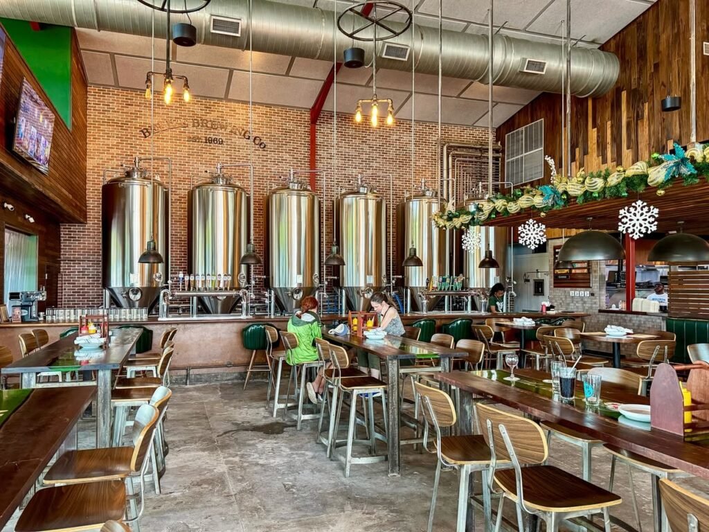 A spacious brewpub featuring stainless steel tanks, brick walls, and festive holiday decor. Patrons enjoy meals in this cozy Pacific Northwest dining hall.