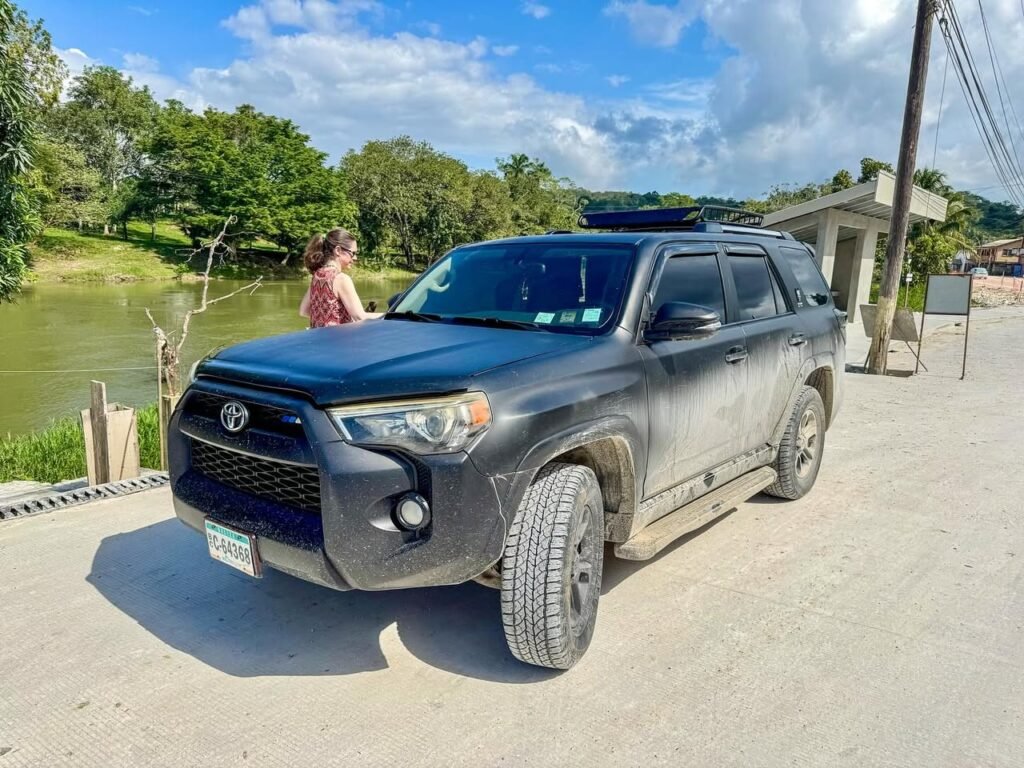 Muddy Toyota 4Runner parked near tropical river
