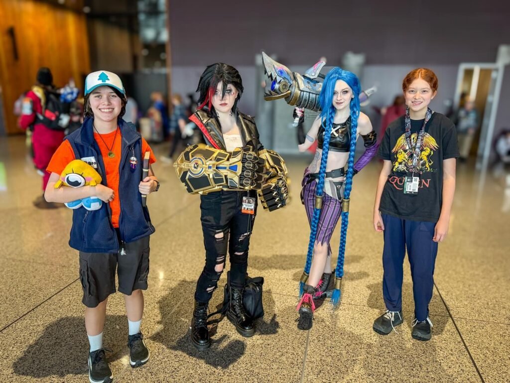 A group photo with two cosplayers and two boys, including one in a Hollow Knight costume. cosplayer from the Game of the Year award ceremony at fan convention.