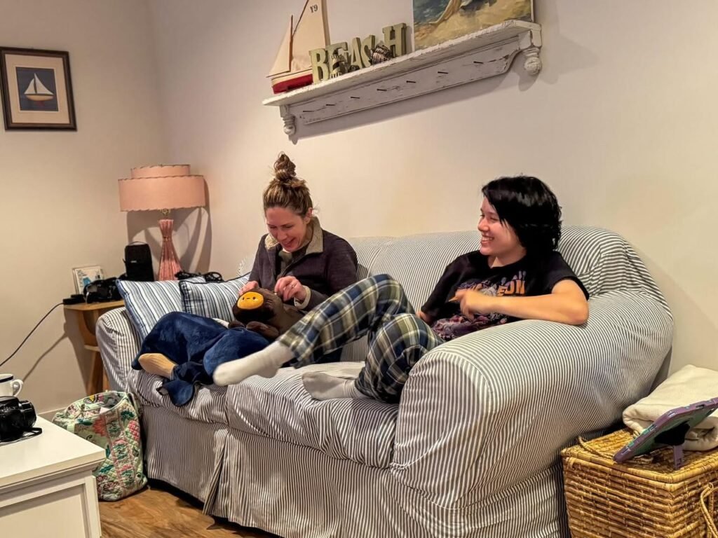 Two people enjoy a relaxed evening on a striped couch in a cozy home setting.