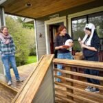 People are enjoying their time on a wooden deck, sharing a moment together.