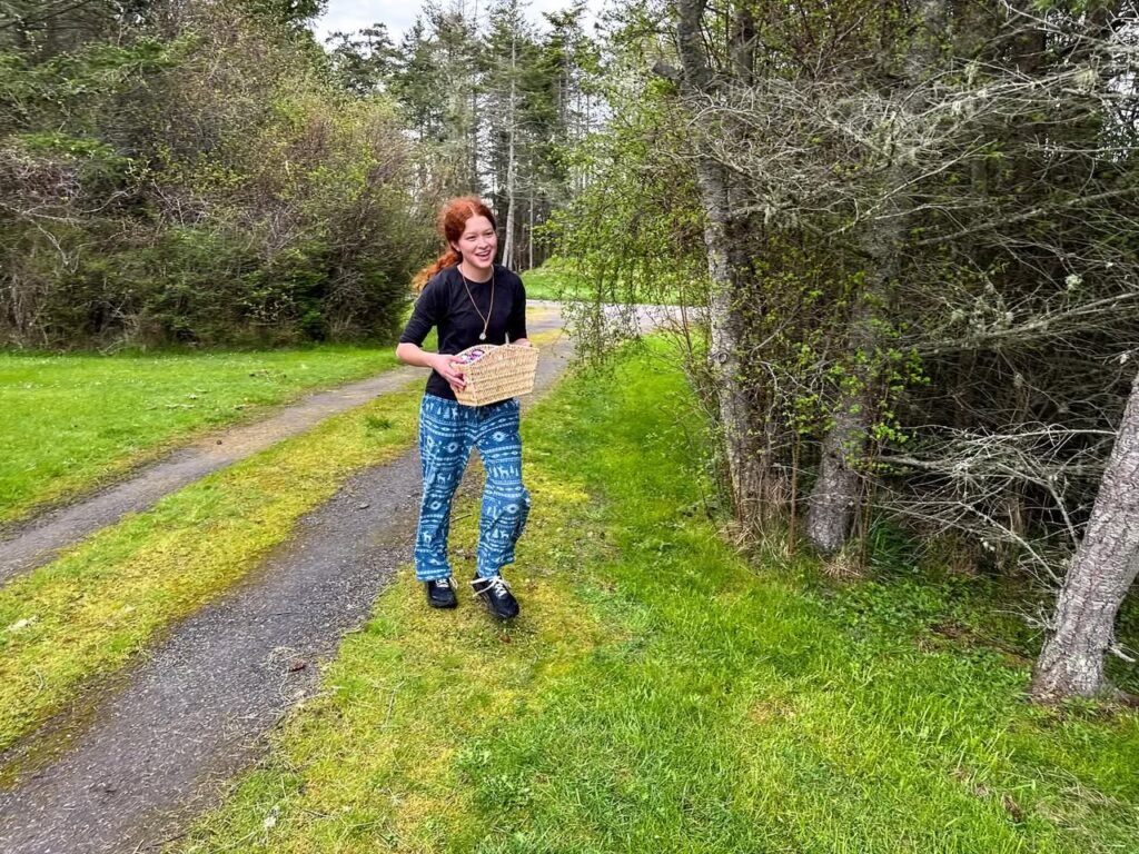 A person walks along a grassy wooded path in the Pacific Northwest. Nature scenery with trees and greenery.