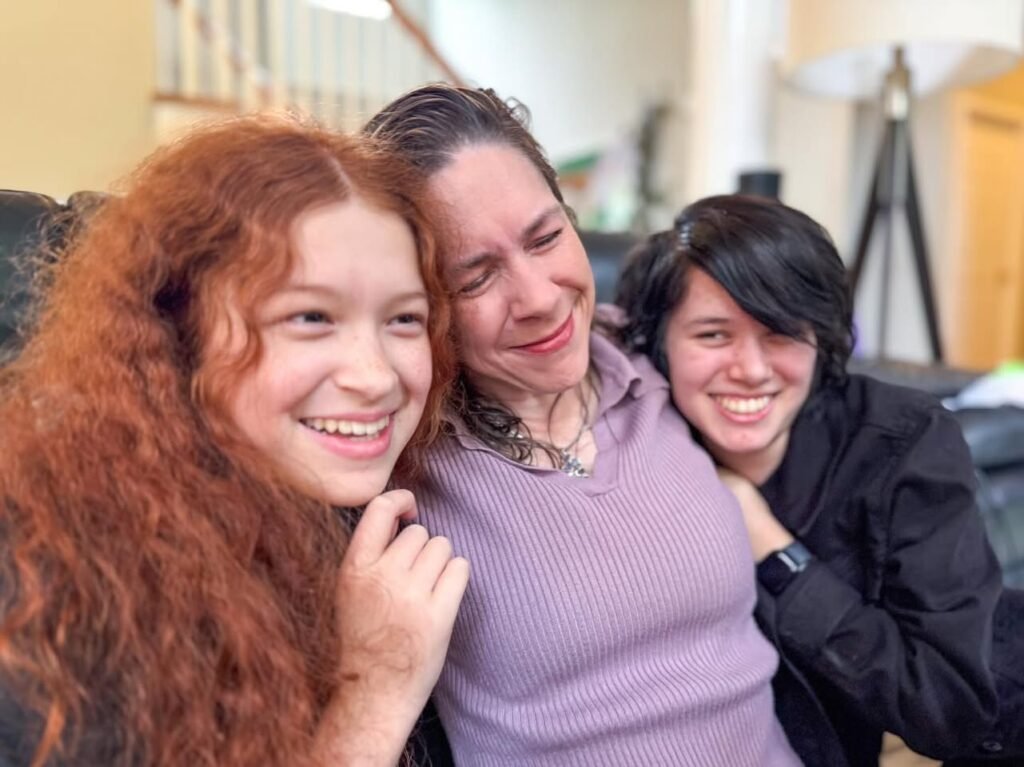 A warm and playful moment of a family huddled together on a couch, sharing genuine smiles.