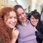 A warm and playful moment of a family huddled together on a couch, sharing genuine smiles.