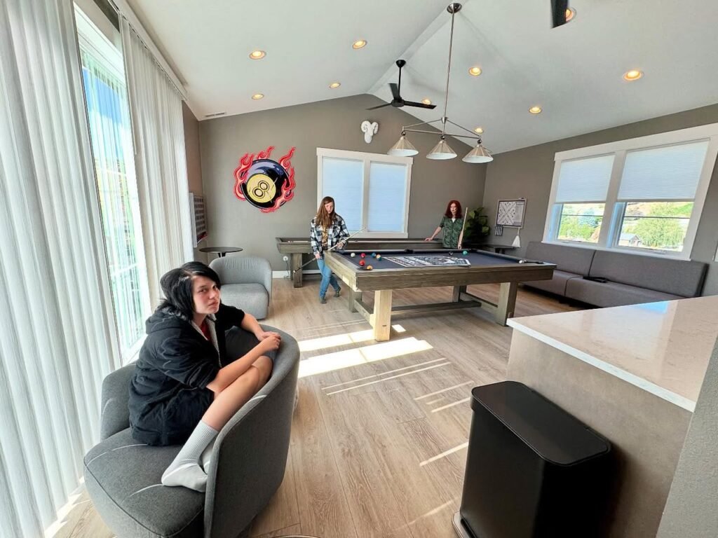 Sliding screen enclosure in a home's media room. Natural light fills the space with views of the outdoors through the screen windows.