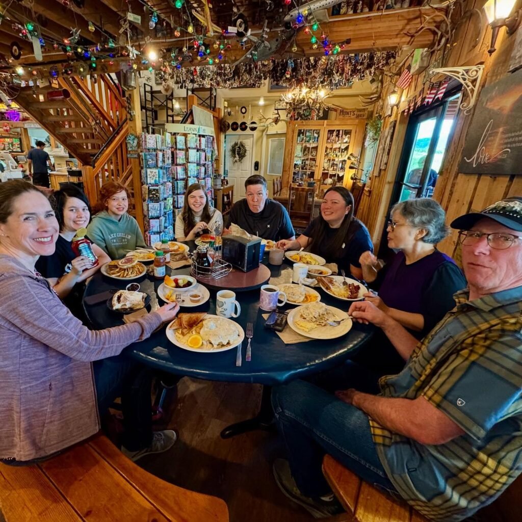 Group of people enjoying a meal at a rustic restaurant table.