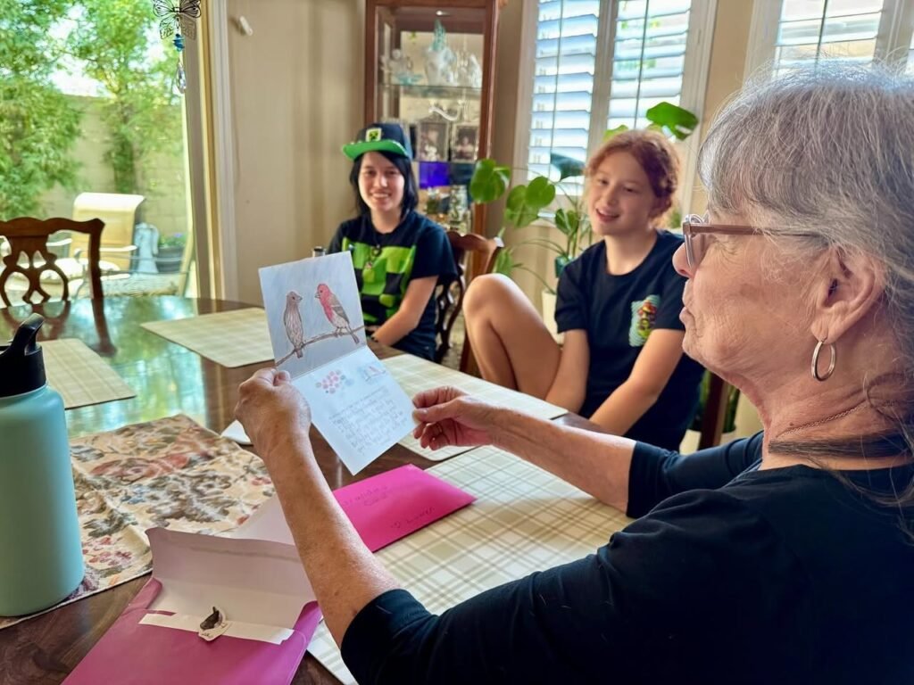 People sitting together at a table with a letter open in hand.