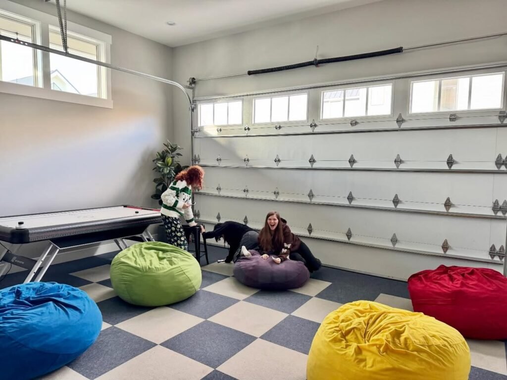 A renovated garage with checkered floors, colorful bean bags, and a ping pong table.