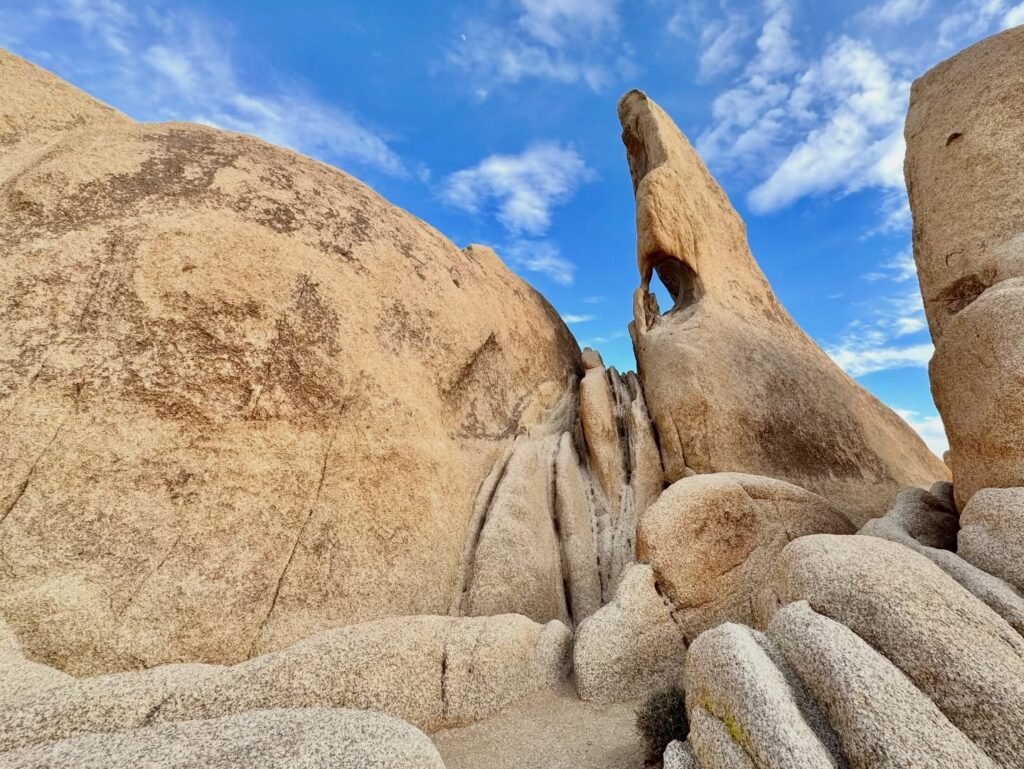 Split image showing a natural rock arch on a desert hillside under a blue sky. Close-up details of the weathered granite surface are visible.